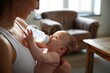 © Margarita - Happy mother holding and feeding her baby with a bottle in a cozy living room filled with natural light