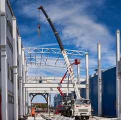 Poster - truck crane lifts metal structures at construction site
