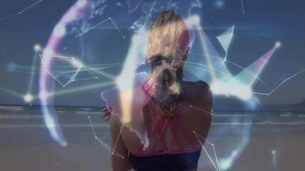 Poster - Woman bringing arm across chest on beach, activating fitness tech mesh morphing into glowing globe
