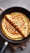 © Sergey - Golden pancake in frying pan on gray background