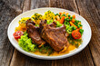 © Jacek Chabraszewski - Baked veal chops, boiled potatoes, green peas and carrots on wooden table