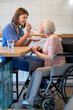 © zinkevych - Care assistant feeding elderly lady and both looking contented