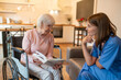 © zinkevych - Care assistant with her elderly patient enjoying reading and looking happy