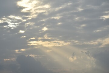Wall Mural - sun spreading light thourgh dark rain cloud floating on sky at sunset in evening