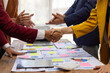 © Wasan - Business people shaking hands after successful meeting. Two business people shaking hands while their colleagues are clapping, after reaching an agreement during a productive meeting.