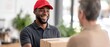 © watcharee - A cheerful delivery person hands a package to a customer indoors.