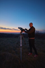 Wall Mural - amateur astronomer using telescope and smartphone for watching stars, moon, planets and other celest