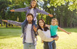 © Studio Romantic - Cheerful father giving piggy back to his son, lovely mother carrying daughter on hands while spending free time in park. Happy family enjoying nice spring day outdoors. People and leisure