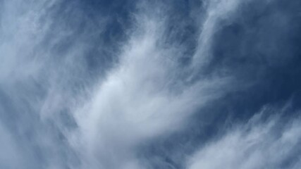 Wall Mural - Timelapse of interesting white to light-blue clouds drifting through a bright blue sky
