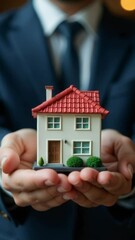 Aufkleber - A person holding a miniature house model, likely used for presentation or demonstration purposes