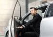 © Prostock-studio - Successful middle-aged entrepreneur getting in expensive car, driving to airport, side view. Smiling bearded businessman sitting in car, going to business meeting or conference, empty space