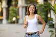 © JackF - Carefree attractive young woman in mid twenties with fair skin and long hair walking outside on warm sunny summer day, dressed in casual jeans and white top. Cropped shot