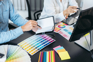 Poster - Two creative graphic designer team working on color selection and drawing on graphic tablet, Color swatch samples chart for selection coloring in inspiration to creativity at workplace