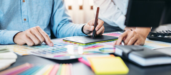 Poster - Two creative graphic designer team working on color selection and drawing on graphic tablet, Color swatch samples chart for selection coloring in inspiration to creativity at workplace
