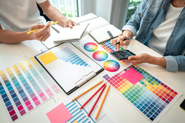 Poster - Two creative graphic designer team working on color selection and drawing on graphic tablet, Color swatch samples chart for selection coloring in inspiration to creativity at workplace