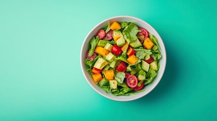 Poster - Fresh salad with avocado, mango, tomatoes, and spinach in a white bowl on a teal background.