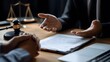 © Jinyang - A lawyer in a dark suit is explaining legal documents to a client with a gavel and scales of justice on the desk.