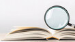 © ArtSync Studio - Magnifying glass rests on open book providing a detailed view of learning and discovery process.