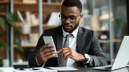 Poster - Focused businessman checking his smartphone at modern office workplace setting