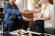 © Apichat - A man and a woman shaking hands in a business setting