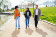 © Koldo_Studio - Three young professionals enjoying a conversation while walking in a city park next to a small pond, discussing business and enjoying the fresh air