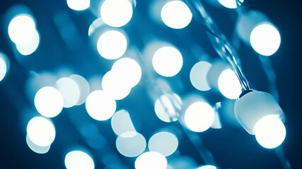 Poster - Abstract Teal Blue Background with Blurred Glowing Light Bulbs Hanging from Strings for Christmas and Holiday