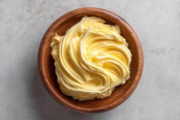 Poster - Freshly whipped butter in a wooden bowl on a light textured background