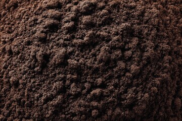 Poster - Ground coffee fills the surface with rich texture showcasing its deep brown color and fine grains during midday light