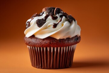 Poster - Decadent chocolate cupcake topped with cream and cookie crumbles on warm orange background