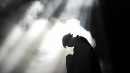 Poster - A person sits on a chair in a dimly lit space, with shadows surrounding them