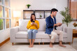 © NT_studio - Unhappy asian couple sitting on sofa having relationship problem in living room at home, emotion conflict and disconnect, couple with frustrated and disappointed, ignoring and trouble with expression.
