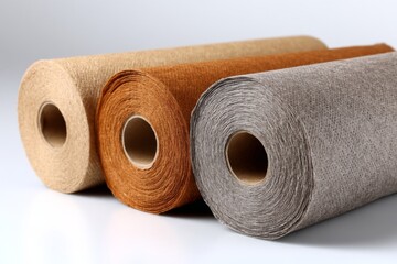 Poster - Rolls of natural paper in various colors displayed on a white background for crafting or packaging purposes