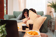 © Kiattisak - Asian Women Snack Food Eating Lifestyle Indoor Living Room Enjoyment Movie, Two Young Adults Sharing Laughter and Snacks While Watching TV, Embracing Friendship and Relaxation at Home Together