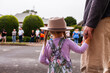 © Austockphoto - Little aussie girl holding parents hand waiting for ANZAC day parade march