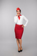 © kegfire - Confident flight attendant in stylish uniform, smiling warmly while striking a thoughtful pose. Perfect representation of professionalism in the airline industry.