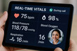 © newlifestock - Real time vitals displayed on tech device during healthcare call with patient consultation at medical center