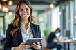 © MDRakibul - Smiling businesswoman using tablet in modern office