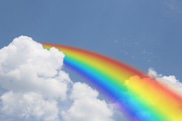 Wall Mural - bright rainbow in blue sky with clouds on sunny day