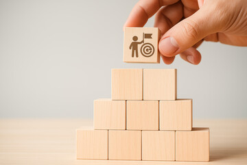 Poster - A strategic approach to achievement is demonstrated by placing a wooden block with a goal icon atop a growing pyramid blocks symbolizing progress and success in business