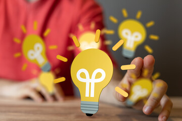 Poster - Stock photo of a person reaching towards glowing lightbulbs, symbolizing innovation and creativity.