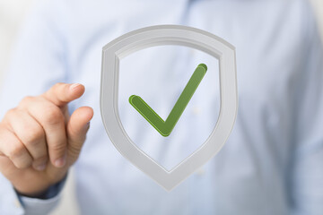 Poster - High-quality image of a person clicking a check mark inside a shield, symbolizing data security and safety.