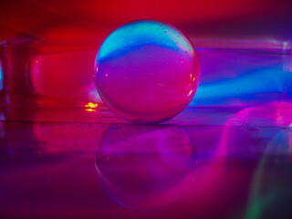 Wall Mural - a clear glass ball is sitting on a pedestal. colorful background. abstract graphic background. light