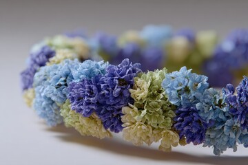 Poster - Delicate blue and purple flowers arranged in a circular wreath, showcasing soft pastel shades and a gentle, romantic floral design on a plain background.