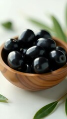 Poster - A wooden bowl filled with black olives, suitable for use in still life photography or as a prop in food-related scenes