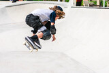 Young skater jumping with his skateboard in a skatepark