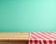 © adobedesigner - Empty wooden deck table and red checked tablecloth over mint wallpaper background