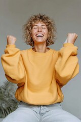 Poster - Joyful Student Celebrating University Acceptance with Raised Arms in Cozy Urban Living Room Featuring Sustainable Home Decor and Indoor Plants
