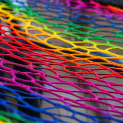 Poster - A close up view of a colorful rainbow net with a repeating pattern and vibrant color gradient shift