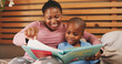 © AzeemudDeen/peopleimages.com - Bedroom, reading book and mother with boy, smile and bonding together with hobby. African family, mama and son with learning, storytelling and child development with knowledge, literacy and home