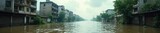 Submerged cityscape, buildings half-hidden beneath a turbulent, murky floodwater A desolate scene of urban decay and the aftermath of catastrophic flooding , submerged, post-apocalyptic, aquatic